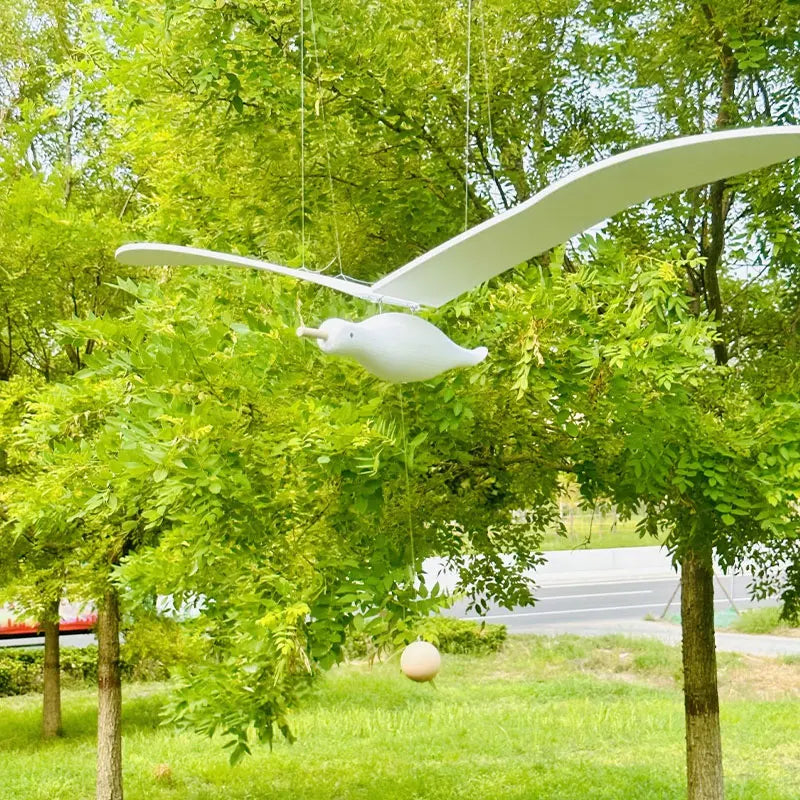 A pair of wooden seagull ornaments carefully handcrafted and suspended in mid-flight, ideal for creating a coastal-themed decor in living rooms, entrances, and balconies. The wings gently animate with wind creating a tranquil beachside ambiance, making it suitable for beach house decor or sea-themed party decorations.