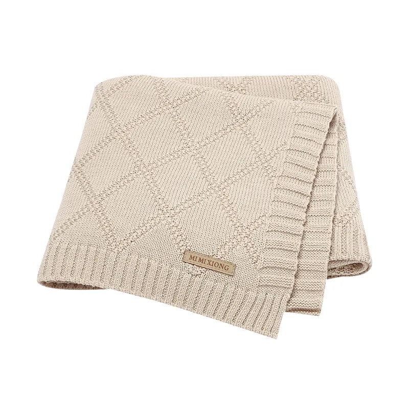 A soft cotton baby blanket in a neutral color, perfect for newborns and toddlers.