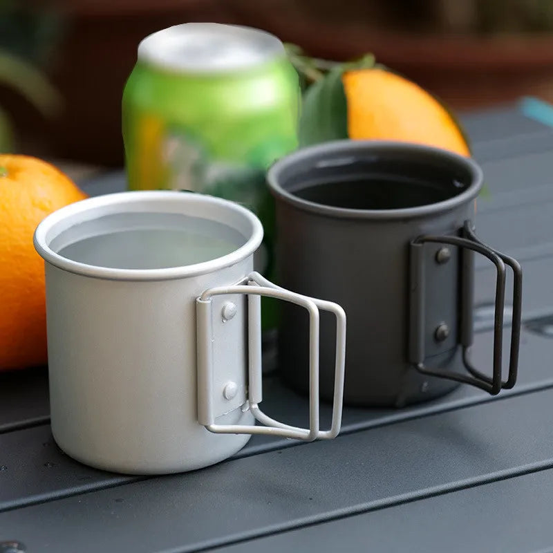 A robust and lightweight 300ML Aluminum Alloy Cup with a foldable stainless steel handle, perfect for outdoor cooking during camping or hiking. Exhibits great durability through its superior hardness and excellent corrosion resistance. Lightweight, portable, heat-resistant, and has food-grade certification.